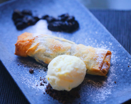 Macro photo of bright blueberry pie and ice cream on a dark plateの写真素材