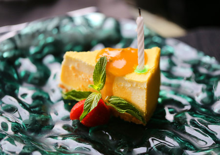 Photo macro of a delicious mango cake on a green glass plateの写真素材