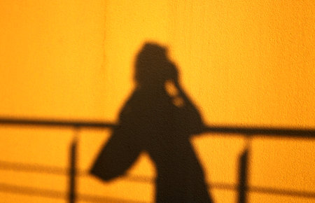 Background shadow of a girl on the wall sunsetの写真素材