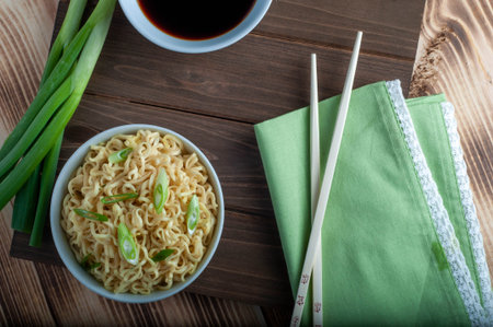 Flat lay overhead shot of ramen noodles in a bowl with soy sauce green onions and chop sticksの写真素材