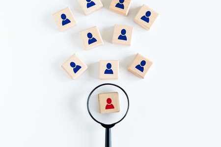Human resources management and recruitment business hiring concept, professional staff research, head hunter job, magnifying glass looking for red employees icon on wood cube.の写真素材