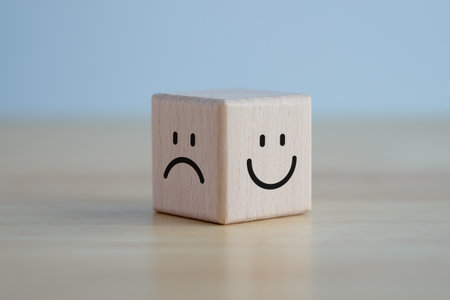 happy face and sad face on wooden block cube for positive mindset selection, Service rating, satisfaction concept.の写真素材