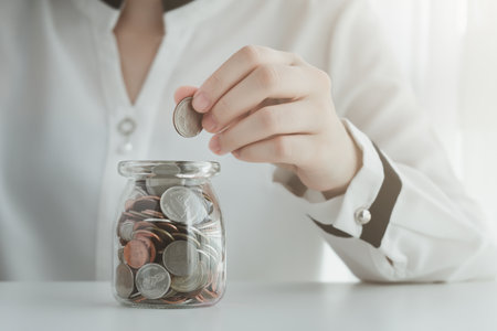 Hand hold coin for put on money box. Financial and business, saving money, loan, tax, interest rate, plan for investment in the future concept.の写真素材