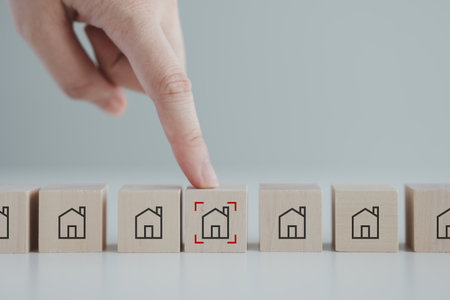 Hand point to house icon with focus frame on wood block. Real estate, Property investment and asset management concept. Decision to choose best property with your right. Choosing suitable housing.の写真素材