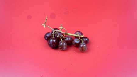 Fresh red grapes in a bowl isolated on pink background. Selective focus on the fresh red grapes.の写真素材