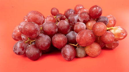 Fresh red grapes isolated on pink background. Selective focus on the fresh red grapes.の写真素材
