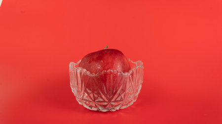 Red apples with water drops, isolated on red backgroundの写真素材