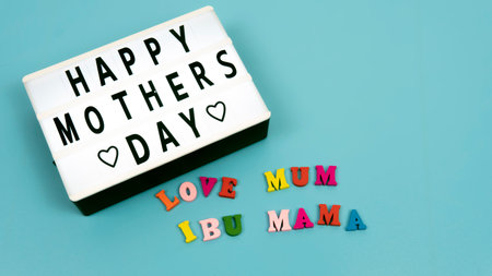 Selective focus of Happy Mother's Day text with a blue background. MOther's Day Celebrate on every May each year. Word "IBU" is mean mother in english.の写真素材