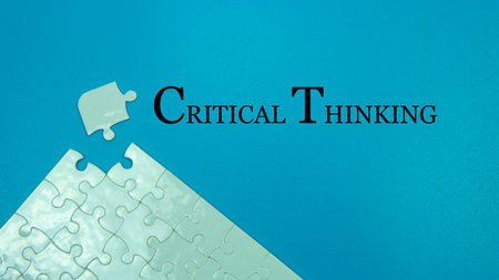 Selective focus of a uncomplete puzzle that has two piece missing. A quote of a text Critical...