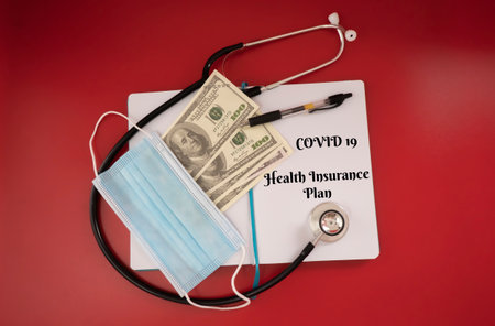 Covid 19 Health Insurance Plan during pandemic. Selective focus on a fake money, mask, a pen, note book and statescope. Health insurance and business conceptの写真素材