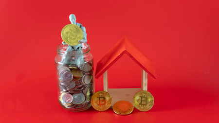 Property investment, house mortgage financial planning and real estate home refinancing concept. Selective focus on a toy house and a doll with a bottle of coinsの写真素材