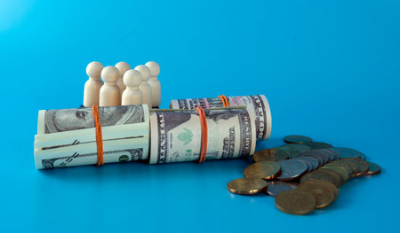 Wooden figures of people standing on money saving for concept investment mutual fund finance and pension retirement.Financial growth conceptの写真素材