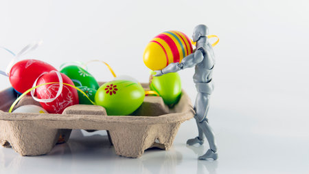 Selective focus of a doll collecting an easter egg. Easter eggs, also called Paschal eggs, and Egg of Easter are eggs that are sometimes decorated. cor fetival or celebrationの写真素材