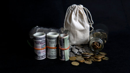 Saving Concept. Selective focus on the money and coins isolated on black background
