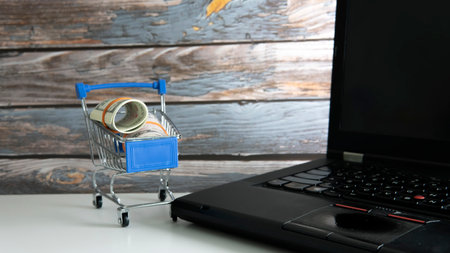 Shopping Sale Discount Concept. Selective focus on the shopping cart, fake money and coins.の写真素材