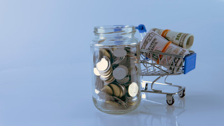 Shopping Sale Discount Concept. Selective focus on the shopping cart, fake money and coins.