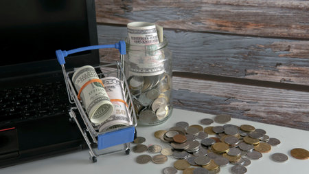 Shopping Sale Discount Concept. Selective focus on the shopping cart, fake money and coins.