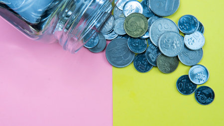 Saving or Econonomy or Business Concept. Selective fous on coins on a pink and yellow backgroundの写真素材