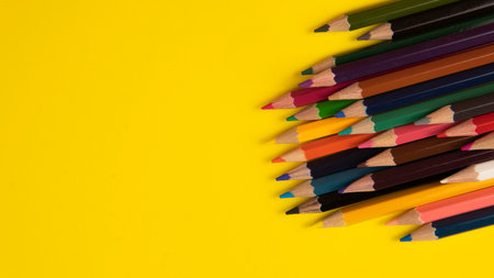 A group ofcolor pencil on a yellow background with a selective focus on the pencil color.の写真素材