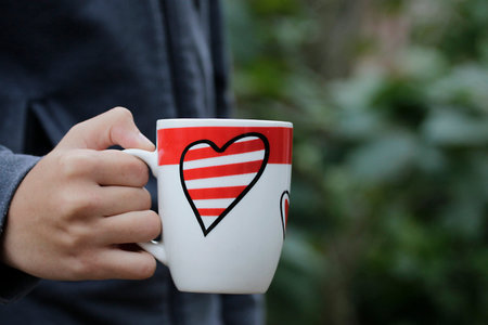 Hand held heart drawing coffee cupの写真素材