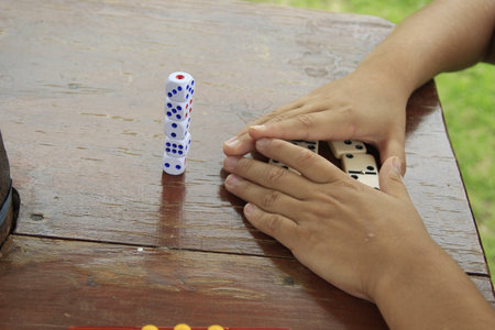 Playing dominoes on wooden table in the park, Thailand.の写真素材