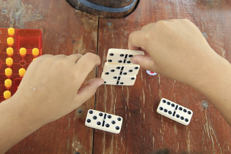 Playing dominoes on a wooden table, closeup of photo