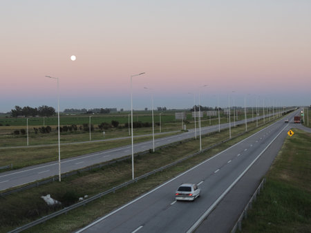 Sunset on a highway in the Netherlands with the moon in the skyの写真素材