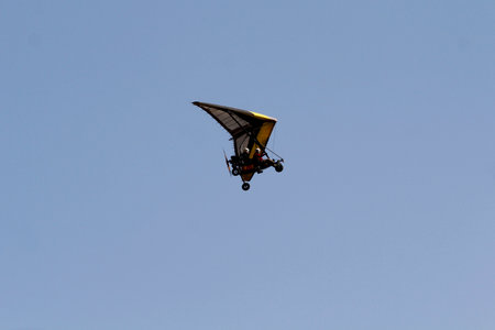 Hang glider flying in the blue sky on a sunny day