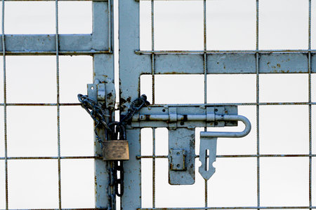 Padlock and chain on a metal gate, closeup of photo