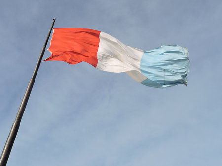 Flag of Province of Cordoba, Argentina, waving in the wind with blue sky as background.の写真素材