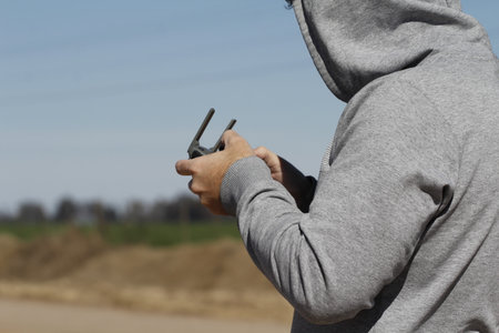 A man in a gray hoodie with a gun in his handの写真素材