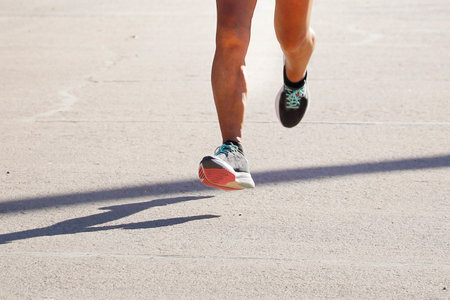 Runner athlete running on city road. woman fitness jogging workout wellness concept.