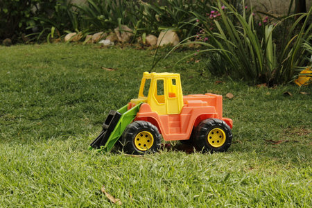 toy tractor on green grass in the garden, closeup of photo