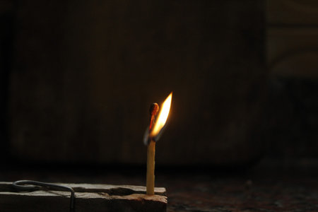 Burning candle on a dark background. Shallow depth of field.