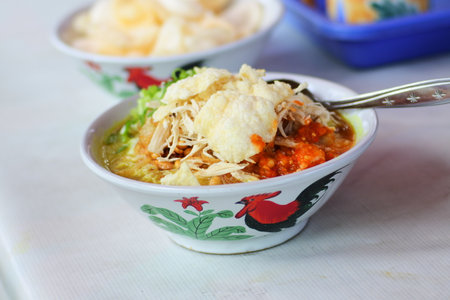rice porridge, known in Indonesia as bubur ayam, served on the bowl with chicken slices and crackerの写真素材