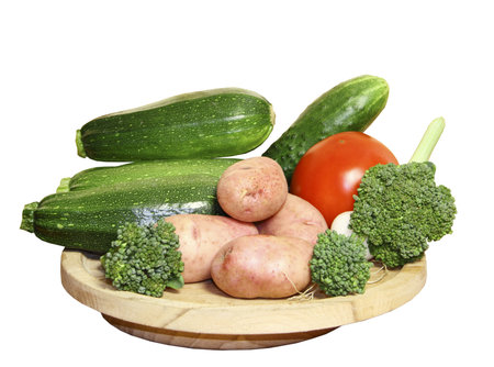 Vegetables on a wooden plate on a white background の写真素材