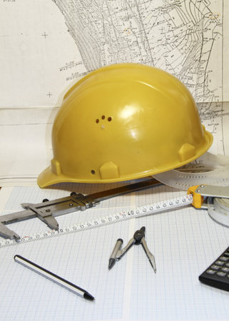 A yellow building helmet, a roulette and compasses the drawingの写真素材