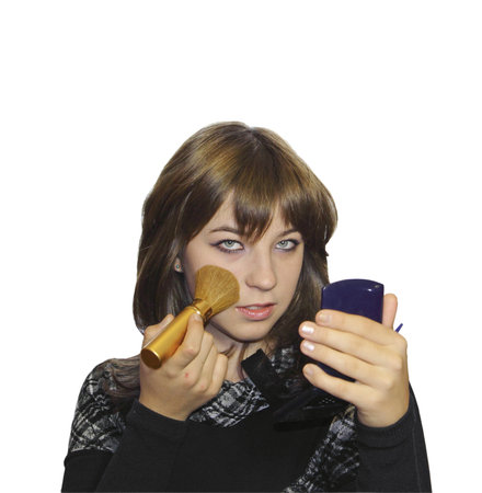 The girl does a make-up with a brush and a mirror in hands on a white background の写真素材