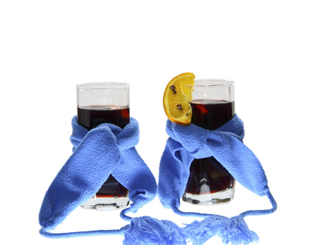 Two glasses of mulled wine with dark blue scarfs on a white backgroundの写真素材