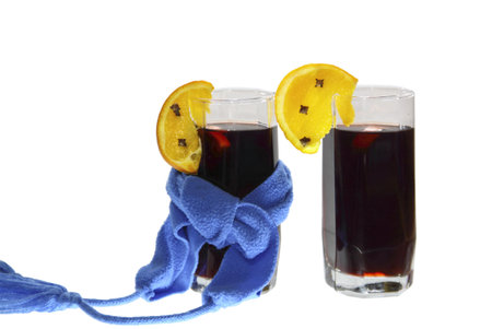 Two glasses of mulled wine with dark blue scarfs on a white backgroundの写真素材