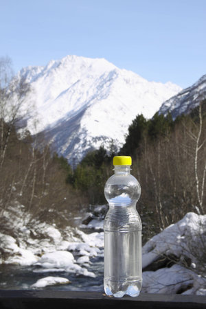 A bottle of pure water against majestic snow top の写真素材