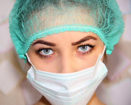 Portrait of a young doctor wearing a mask and hatの写真素材