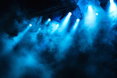 Illuminated stage with scenic lights and smoke. Blue vector spotlight with smoke volume light effect on black background. Stadium cloudiness projector, Generative AI generatedの素材