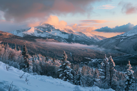 Morning light casts a warm glow on snow-dusted peaks while mist rises from the valley below, creating a tranquil winter atmosphere in the mountains.の素材