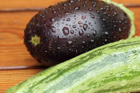 eggplant and zucchini with rain drops on a wet tableの写真素材