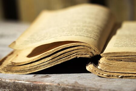 yellowed page of an old book lying on the wooden boardの写真素材