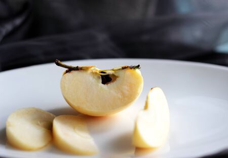 cut into slices of apple on a white plateの写真素材