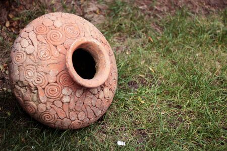 old cracked clay vase with ornaments