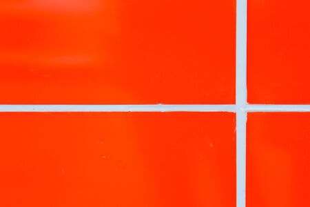 Orange walls with white lines, the two lines intersectの写真素材