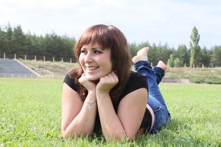 Smiling woman lying on the grassの写真素材
